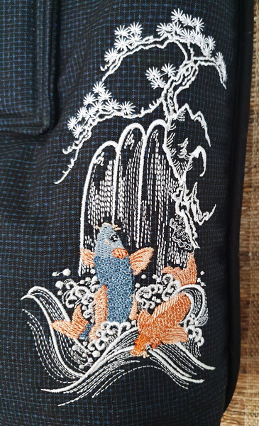 Spring of Life Machine Embroidery Design Bag. Black bag with Koi, waterfall and blossom tree. Close up